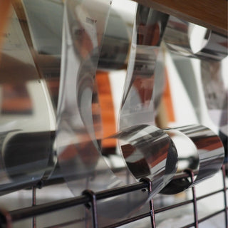 Film negatives up close, curling down from a counter to a metal rack