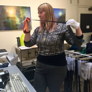 A technician examines a long film negative as she prepares a big scanning order for a customer at Photolab Berkeley
