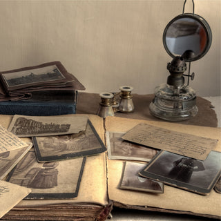 A selection of old photographs from an old album opened on a table for display