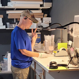 Joel flashes the peace sign while working at Photolab of Berkeley