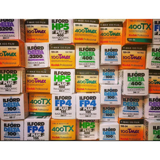 A stack of film boxes from various  manufacturers filling the frame