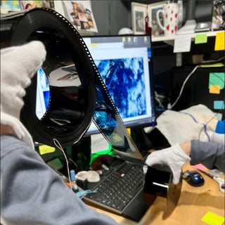 A technician handles 70mm film negatives for an arching project for NASA at Photolab of Berkeley