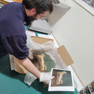 A technician handles a piece of fine art and the fine art print at Photolab of Berkeley