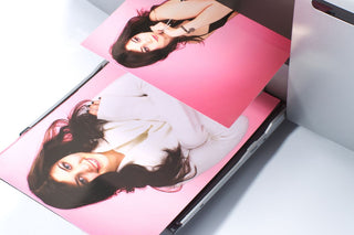 Borderless color prints of a female model emerging from a desktop printer